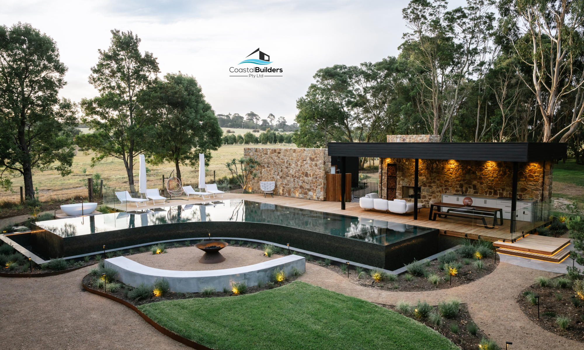 Coastal Builders photo of Resort pool and pool house with stone work, deck and outdoor lighting